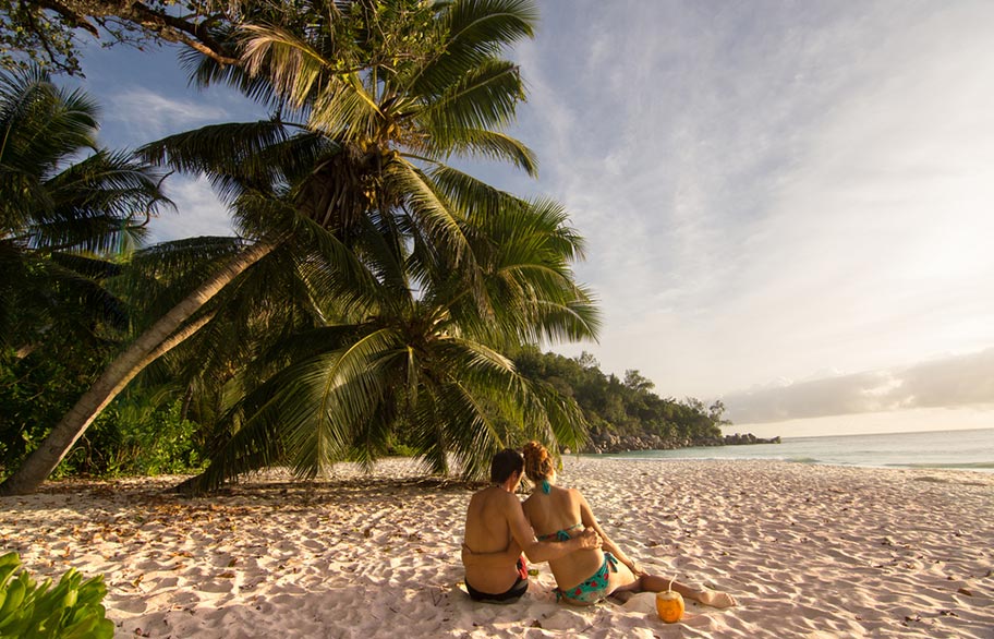 Seychellen Flitterwochen Paar an Traumstrand Seychellen Flitterwochen Paar Kokosnuss Strand